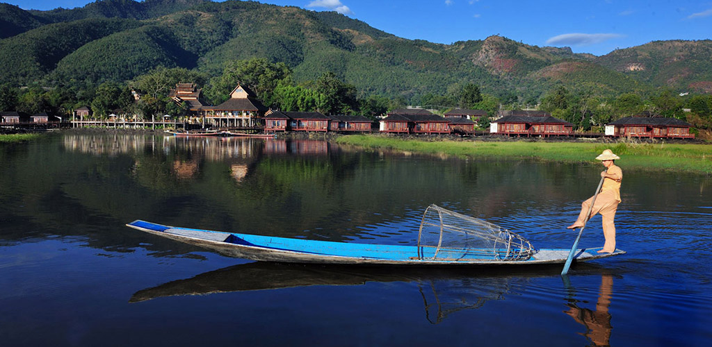 One-legged rower in front of Aureum luxury hotel on Inle Lake, Myanmar