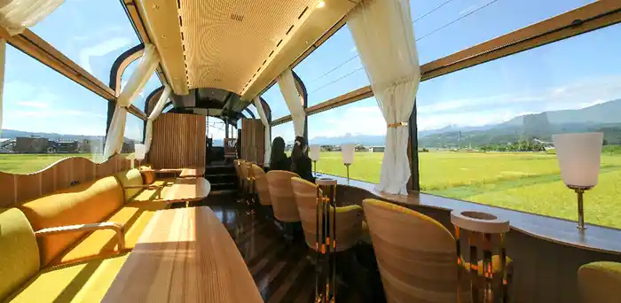 Shiki-Shima luxury train observation car passing fields