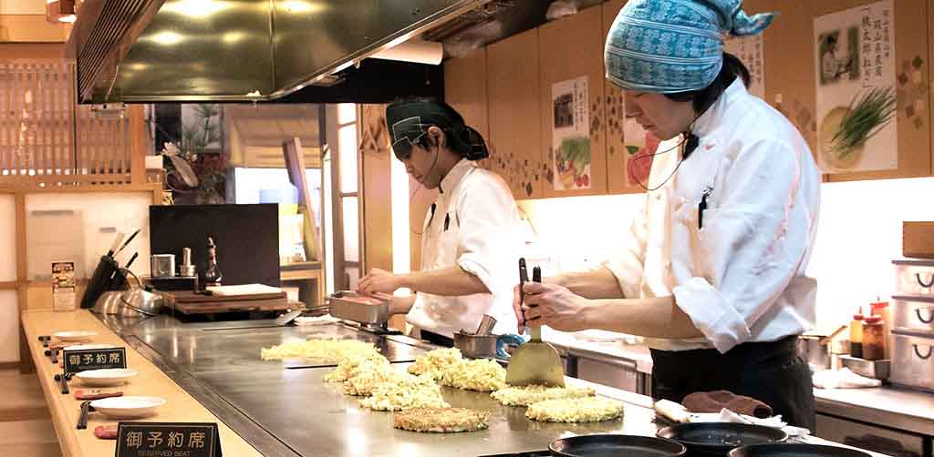 Chefs preparing Okonomiyaki in Japan