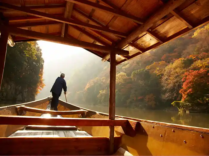 Boatman rowing a traditional boat on the Yoshemine River in Kyoto
