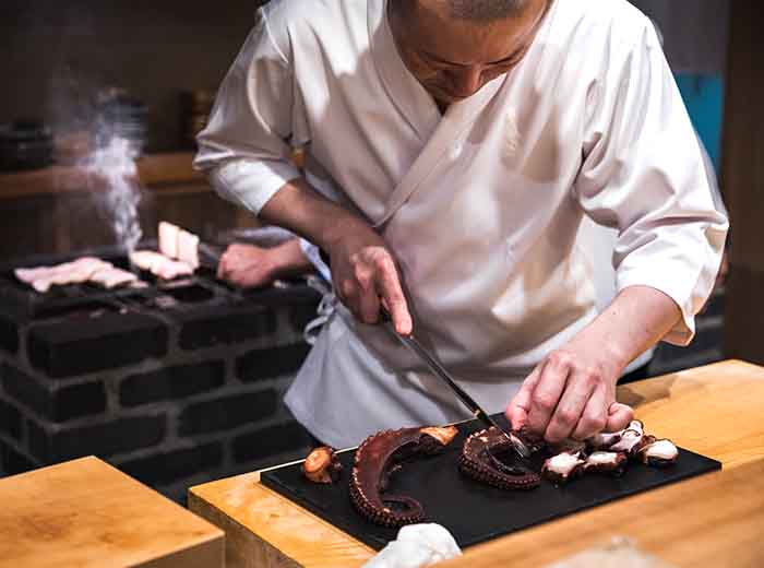 Sushi chef preparing fish in Tokyo, Japan