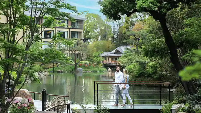 honeymoon couple walking through Japanese garden and pond in Kyoto, Japan