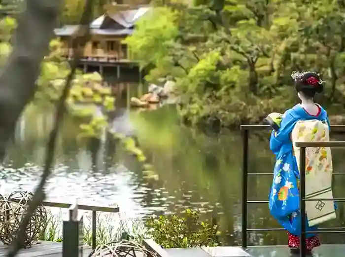 Geisha looking over pond and gradens in Kyoto
