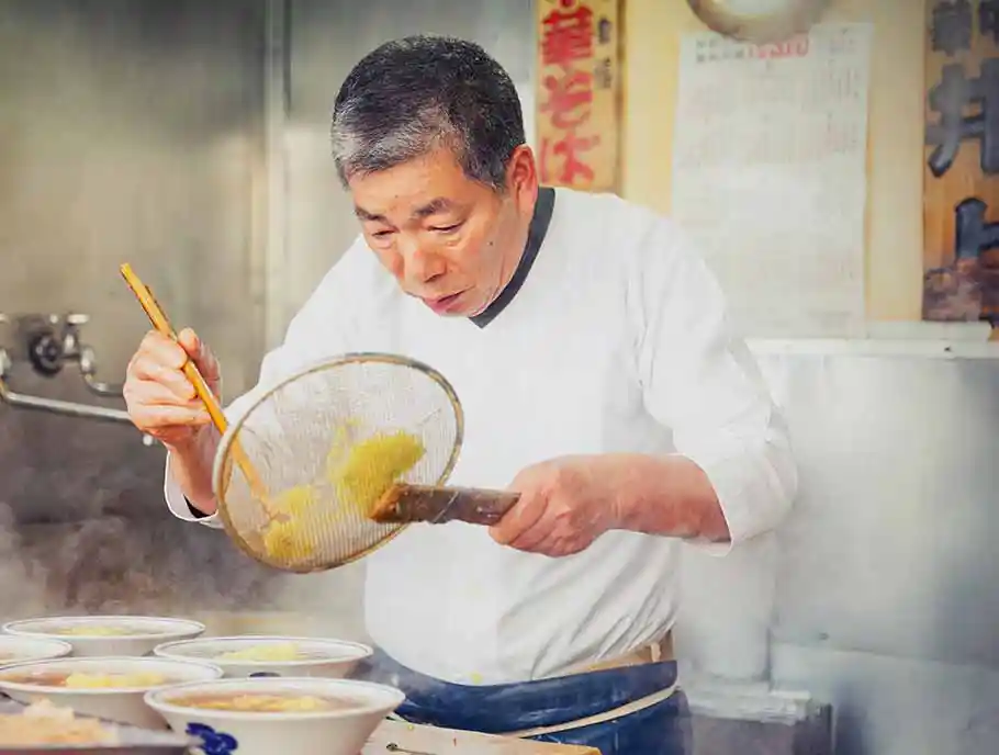 Japanese ramen chef at work in restaurant kitchen