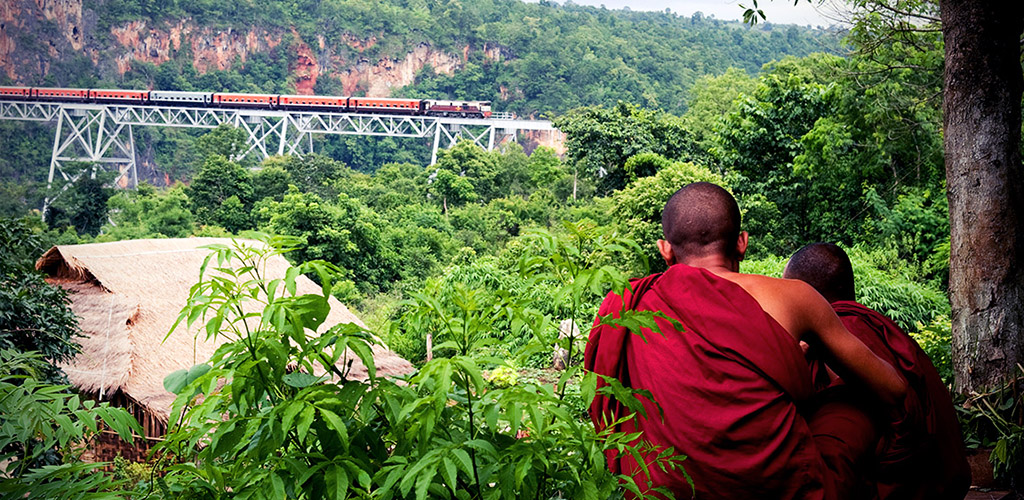 Monks look at train on Goteik Aqueduct in Myanmar
