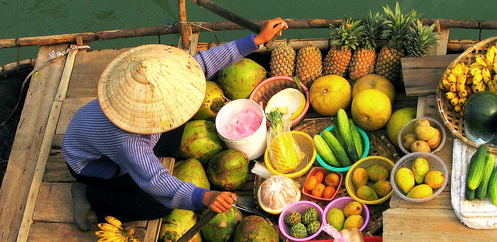 Fruit vendor in boat at flaoting market in the Mekong Delta, Vietnam