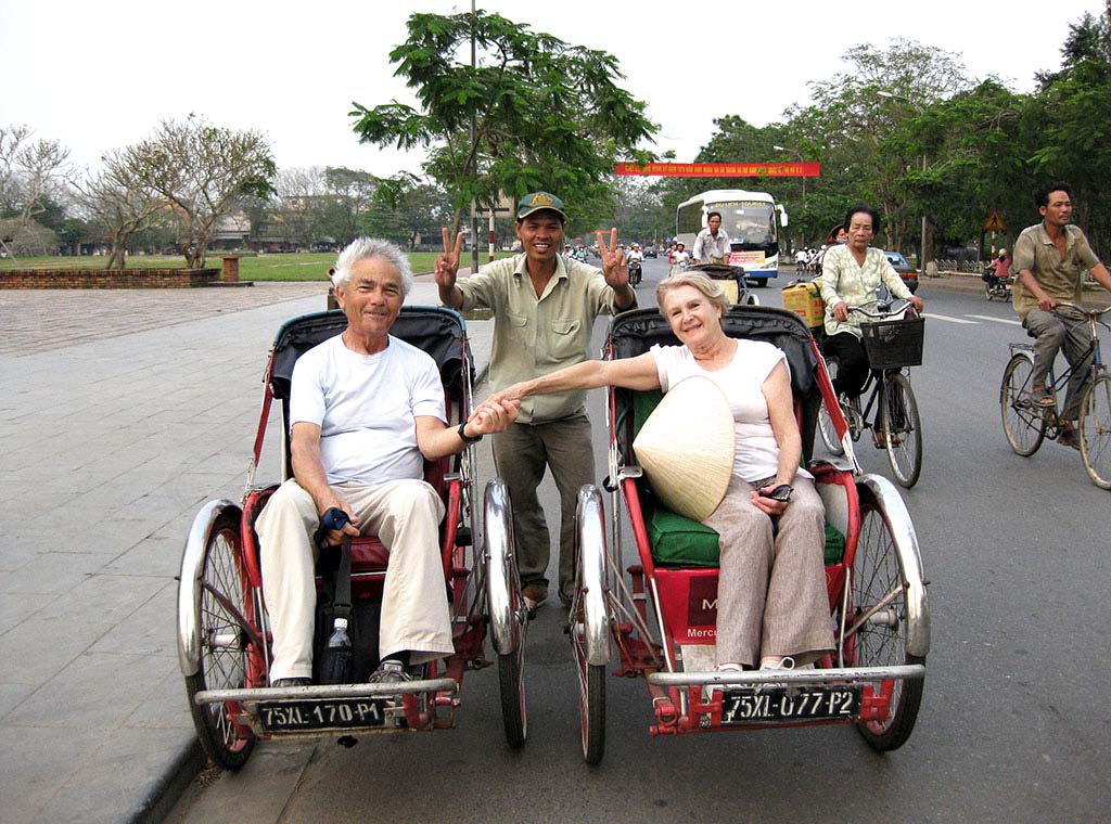 Couple enjoying cyclo tour of Hanoi