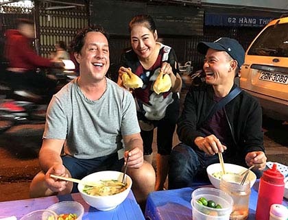 Eating pho on the street in Hanoi during street food tour of the capital city