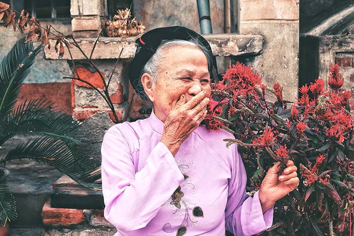Old woman in Hanoi with flowers in Hanoi, Vietnam