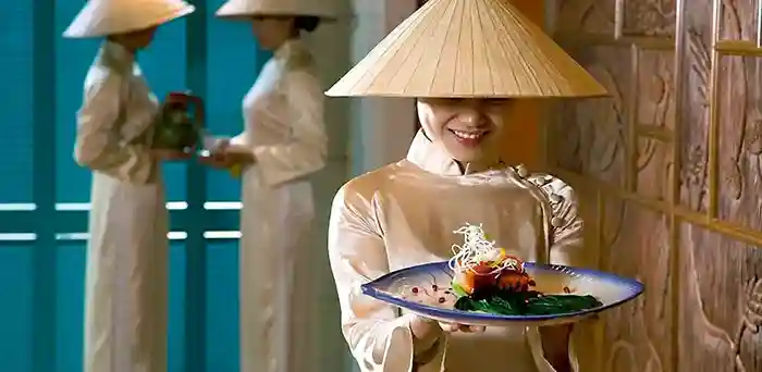 Waitress in in ao dai dress in Vietnam luxury hotel